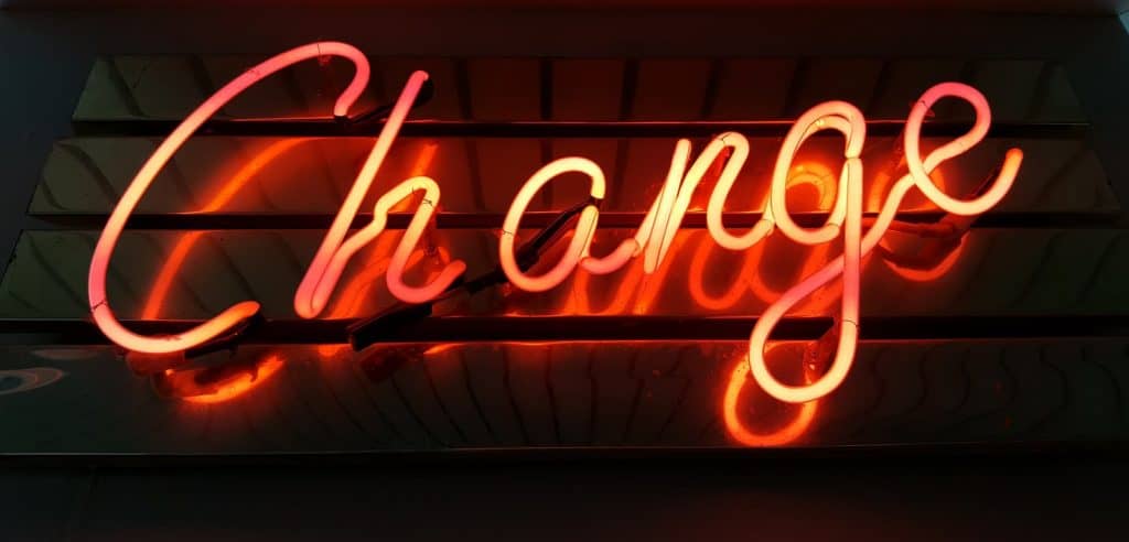 the word "change" written in orange neaon lights on dark background